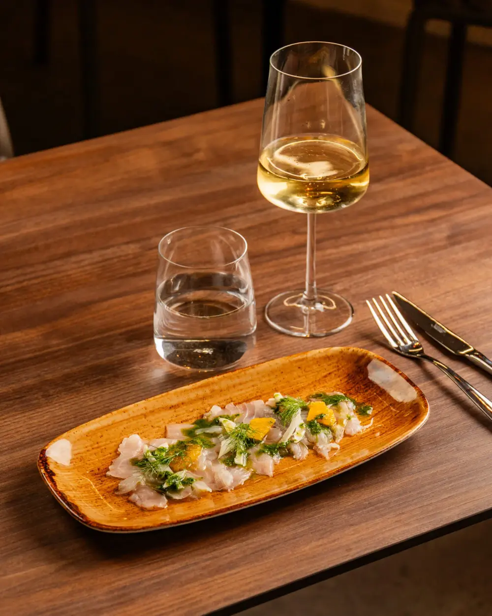 Carpaccio di spigola del Tirreno con arancia, salsa verde e finocchietto