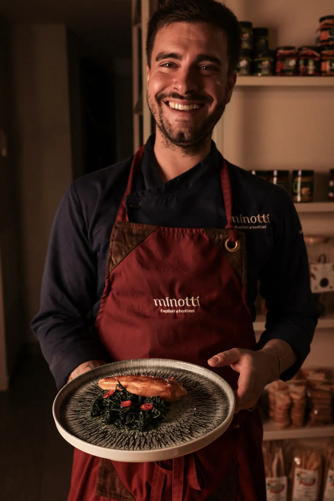 Lo chef Edoardo Minotti con il grembiule Minotti e un piatto di suprema di pollo