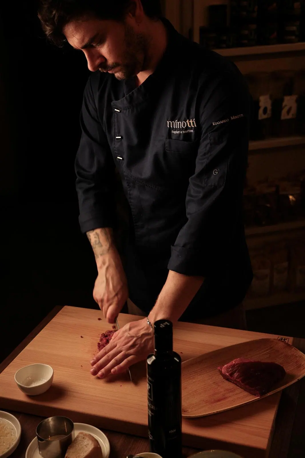 Lo chef Edoardo Minotti taglia la carne su un tagliere durante un evento