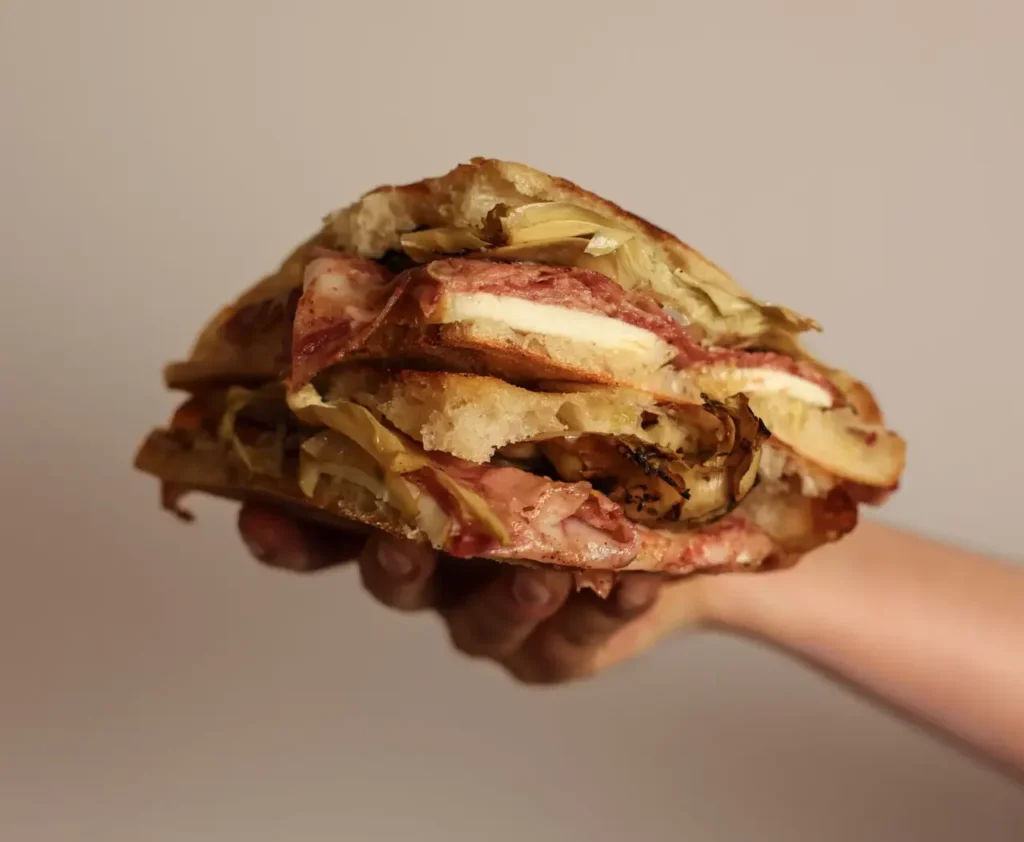 Focaccia La Rustica con coppa di maialino nero, carciofini alla brace e taleggio di capra